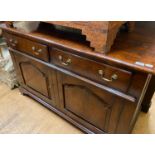 An 18th century style oak dresser base, with two drawer, and two cupboard doors on bracket feet, 142