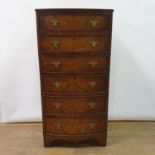 A walnut bow fronted chest, having six drawers on bracket feet, 60 cm wide
