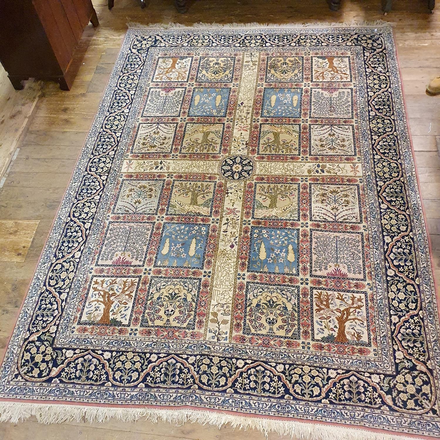 A Persian cream ground carpet, with a main blue border, centre with repeating square medallions, 340