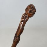 A 19th century folk art walking stick, the handle carved in the form of a menacing looking man