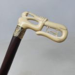 A walking stick, with carved ivory handle in the form of a hand grasping a snake, on a rosewood