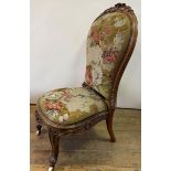 A 19th century rosewood nursing chair, with floral tapestry back and seat, on carved cabriole legs