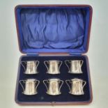 A set of six Arts & Crafts silver tots, in the form of tygs, Sheffield 1924, boxed