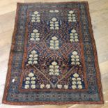 A Persian blue ground rug, with main blue border, centre with repeating foliate forms, 132 x 101 cm