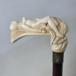 A walking stick, the ivory handle carved in the form of a monk and a nun in an erotic pose, on