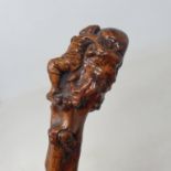 A 19th century folk art walking stick, the handle carved in the form of a lying figure, with another