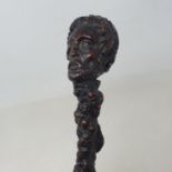 A 19th century folk art walking stick, the handle carved in the form of a man's head, gnarled shaft,