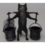 A modern novelty match strike in the form of a cat carrying two buckets, 10 cm high