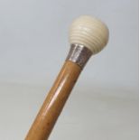 A 19th century walking stick, with carved ivory handle, inset an enamelled coin, 95 cm