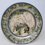 An art pottery plate, decorated a goose, highlighted in gilt, monogrammed NC and dated 1994, 26 cm