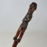 A 19th century folk art walking stick, the handle carved in the form of a full length gentleman