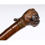 An Arts and Craft shoehorn, the handle carved a bulldogs head, with gilt metal collar and bell, 33