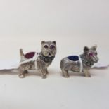 A pair of modern silver coloured metal dog pincushions, 2 cm high