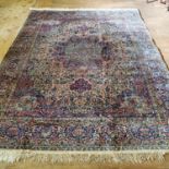 A Tabriz silk and wool cream ground carpet, main blue border, with central flower shaped