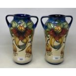 A pair of Moorcroft pottery vases, decorated flowers, with two handles and of waisted form, 25.5