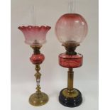 An oil lamp, with cranberry acid etched shade, cranberry well, on brass base, 66 cm, and another oil