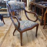 An early 20th century armchair, with a padded back and seat on splay legs