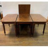 An early 19th century mahogany extending dining table, with a central drop leaf section and an extra