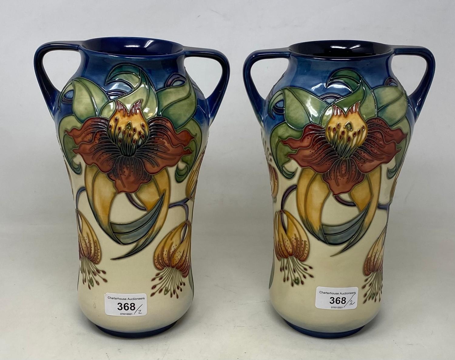 A pair of Moorcroft pottery vases, decorated flowers, with two handles and of waisted form, 25.5