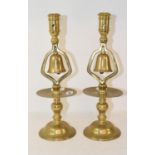 A pair of Victorian brass candlesticks, with bells, with broad drip pans and circular bases, 33 cm