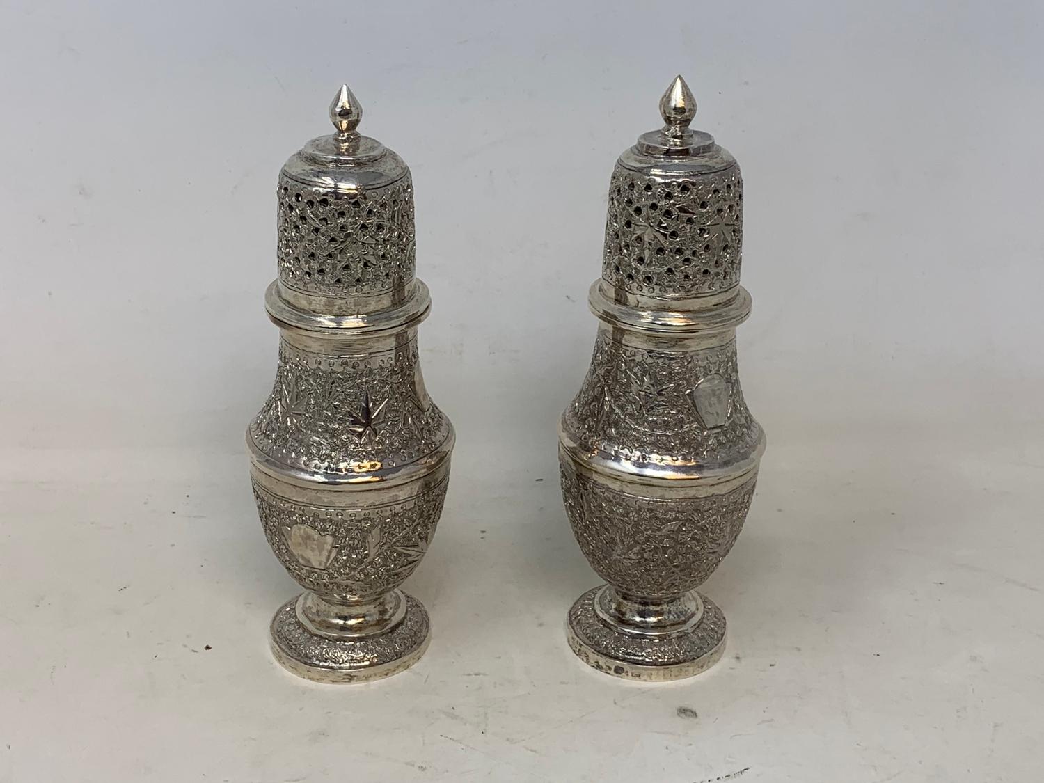 A pair of Burmese style silver coloured metal sugar casters, 15.5 cm high (2) Report by RB 8.6 ozt