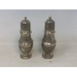 A pair of Burmese style silver coloured metal sugar casters, 15.5 cm high (2) Report by RB 8.6 ozt