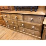 A pine chest, having an arrangement of seven drawers, on a plinth base, 149 cm wide