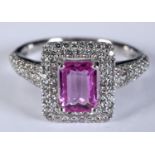 An 18ct white gold, rectangular pink sapphire and diamond halo ring, with diamond shoulders, the