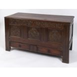 A late 17th/early 18th century oak mule chest, carved tulips, lozenges, flowerheads and scrolling