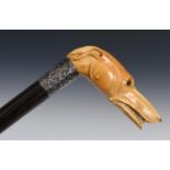 A 19th century walking stick, with a carved ivory handle in the form of a greyhound bearing its