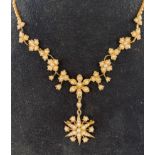 An Edwardian 9ct gold and pearl pendant necklace, in the form of vine leaves and flowers, with a