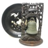 A Chinese bronze bell, in a carved and pierced hardwood frame, 37 cm high, on a later base, and a