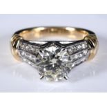 A 14ct gold ring, central diamond of approx. 1.90ct, with three rows of channel set diamonds,