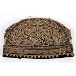 An Indian velvet cap, with gold thread decoration applied gems, 27.5 cm wide See illustration