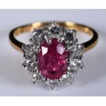 An 18ct yellow and white gold, oval ruby and diamond cluster ring, the diamonds approx. 1.00ct,