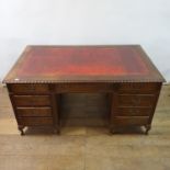 A mahogany pedestal desk, the leather inset top above an arrangement of nine drawers, on dwarf