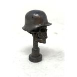 A bronze pipe tamper, in the form of a skull wearing a helmet Report by RB Modern