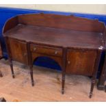 An early 19th century Irish mahogany sideboard, the three quarter gallery back above a central