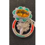 A modern silver coloured metal brooch, inset with a yellow stone, another, embossed with a fox