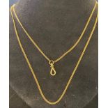 A yellow coloured metal long guard chain, with an unusual clasp for attaching pendants, which screws