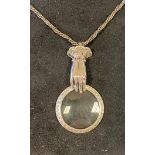 A silver hand magnifying glass pendant, on a chain Report by RB Modern and in good condition