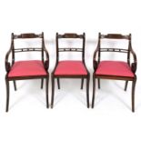 A set of eight simulated rosewood and brass inlaid dining chairs, with drop in seats and sabre