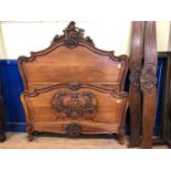 A pair of French walnut bed ends, the footboard carved cherubs, and with rococo decoration, 154 cm