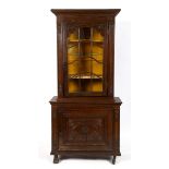A late 18th century Continental oak display cabinet on cupboard, carved flowers and foliage,