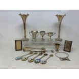 A pair of silver spill vases, Birmingham 1902, loaded, 17 cm high, four small silver trophy cups,