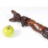 A large and impressive one piece folk art walking stick/staff, carved a sinister looking elf/sprite,