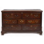 A George III oak mule chest, the lift up top above two false and five real drawers, flanked by