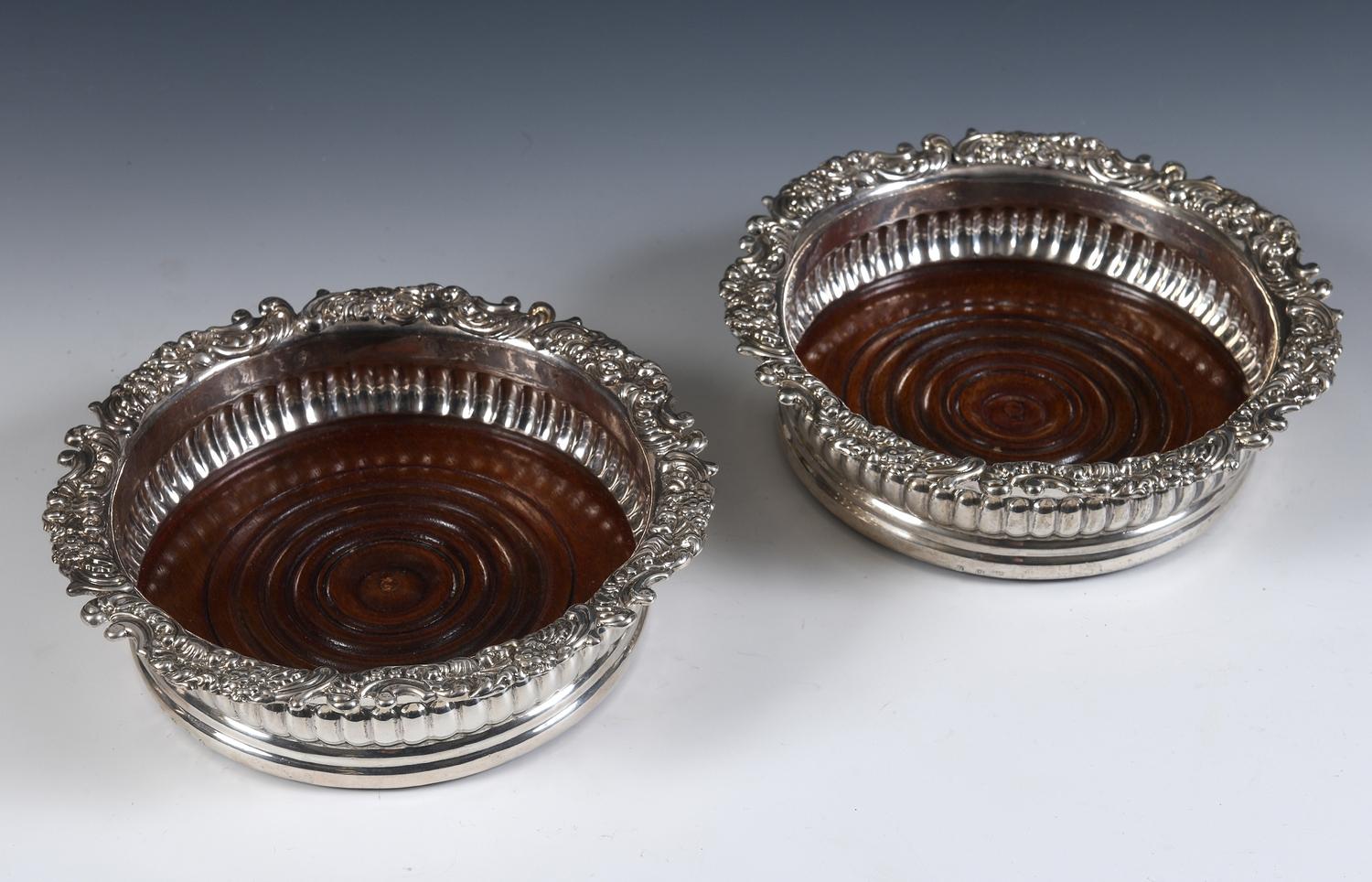 A pair of early 19th century Scottish silver wine coasters, with rococo style edges, a reeded