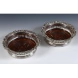 A pair of early 19th century Scottish silver wine coasters, with rococo style edges, a reeded