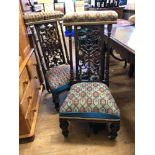 A pair of Victorian rosewood prie dieu chairs, the backs carved and pierced foliage, with woolwork